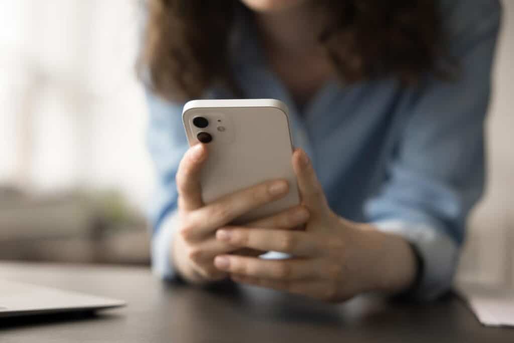 Close up of a woman using a smartphone, representing the HSCGP settlement.
