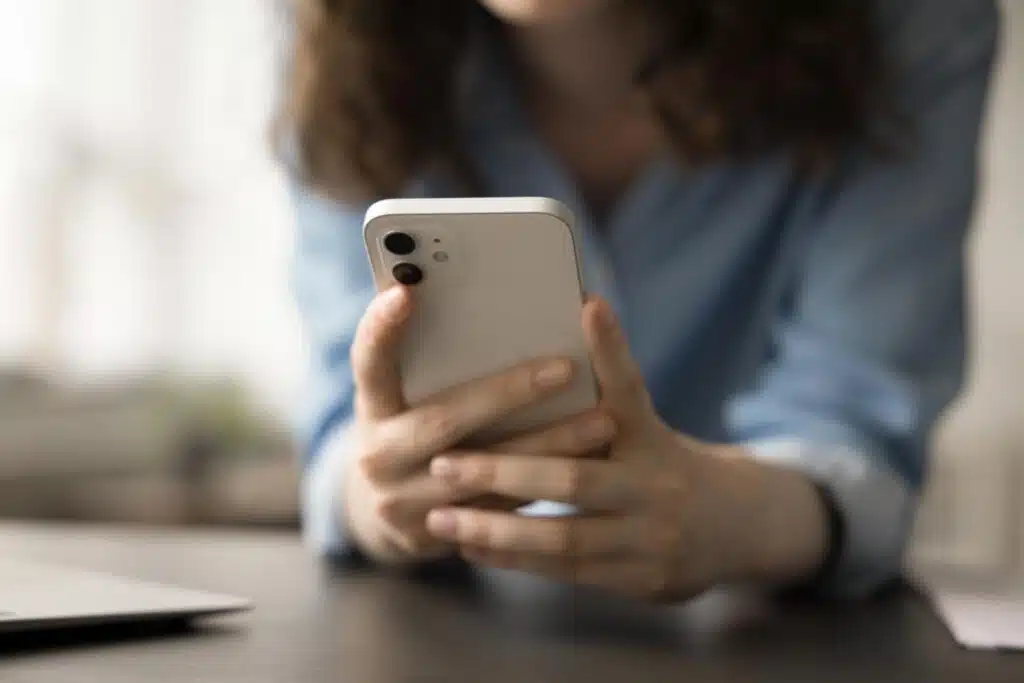 Close up of a woman using a smartphone, representing the HSCGP settlement.