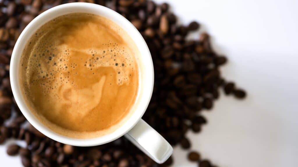 Cup of coffee on the coffee beans background.