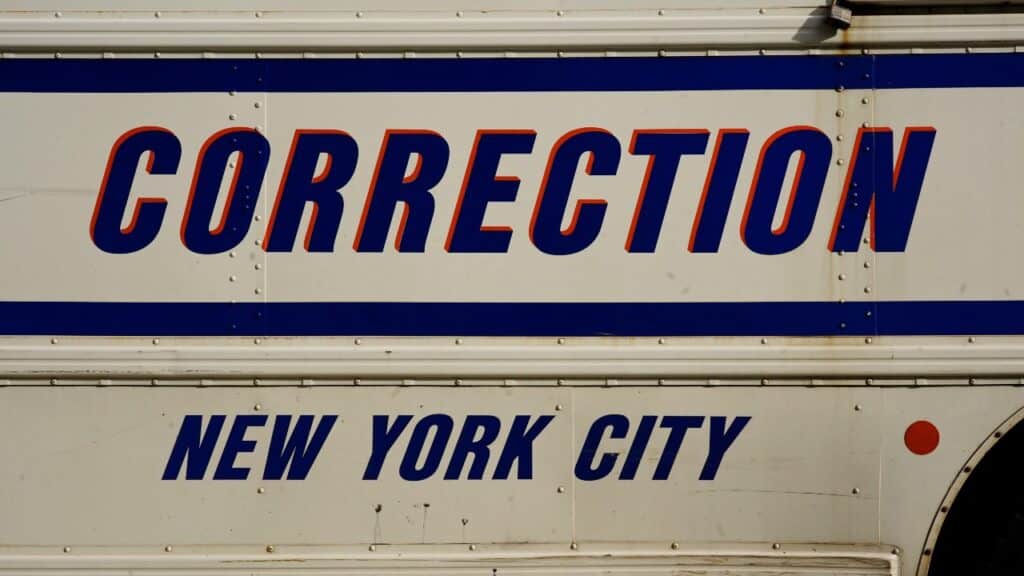 buses adorned with the New York City Correction Department signage.