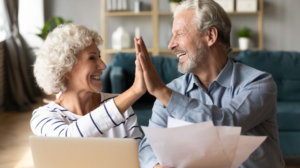 Excited older couple giving high five, received refund