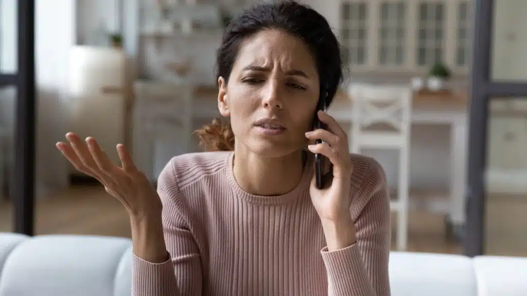 Annoying phone calls, young hispanic female hold phone to ear