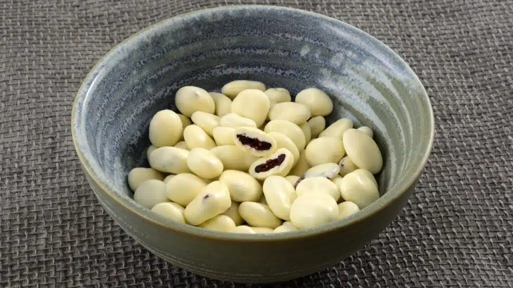 yogurt covered cranberries in ceramic snack bowl on gray burlap