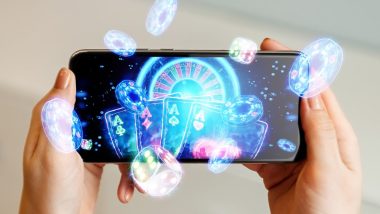 online casino, in a man's hand a smartphone with playing cards, roulette and chips, black-neon background.