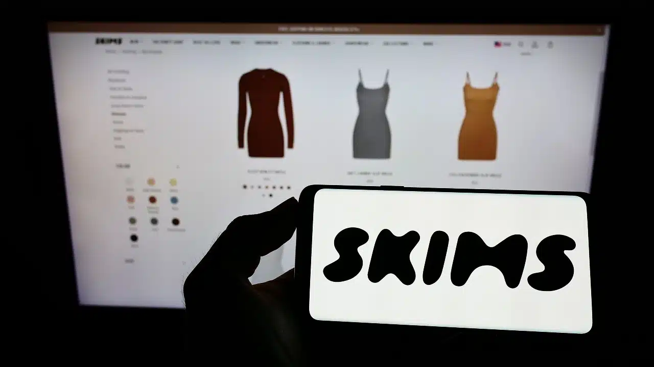 Person holding cellphone with logo of American clothing company Skims Body Inc.