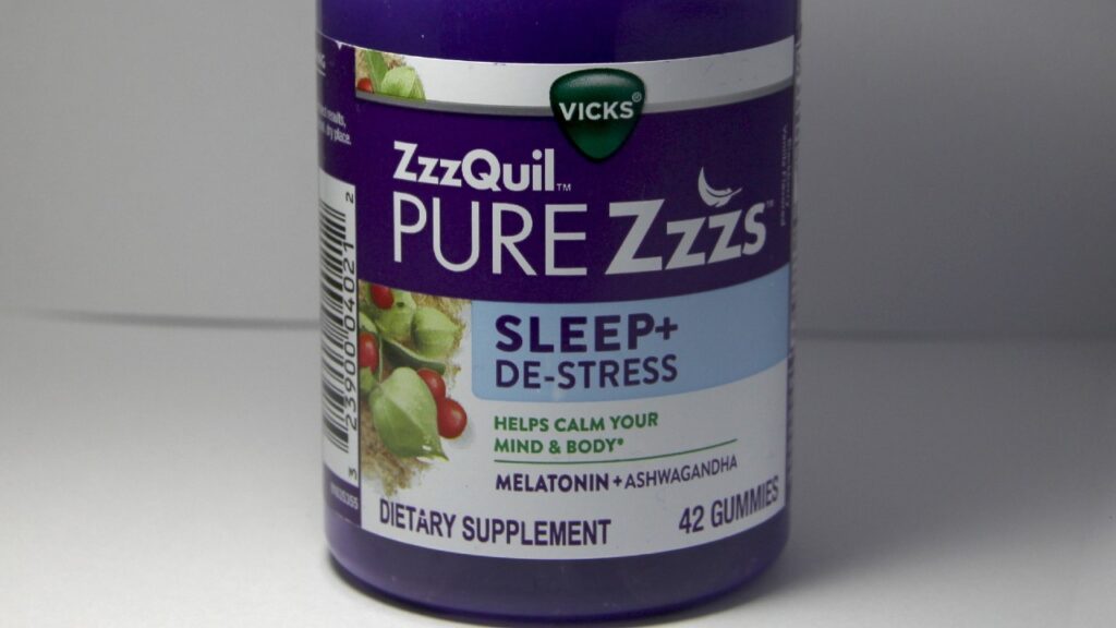 Vicks Pure ZzzzQuil gummy in a purple bottle.