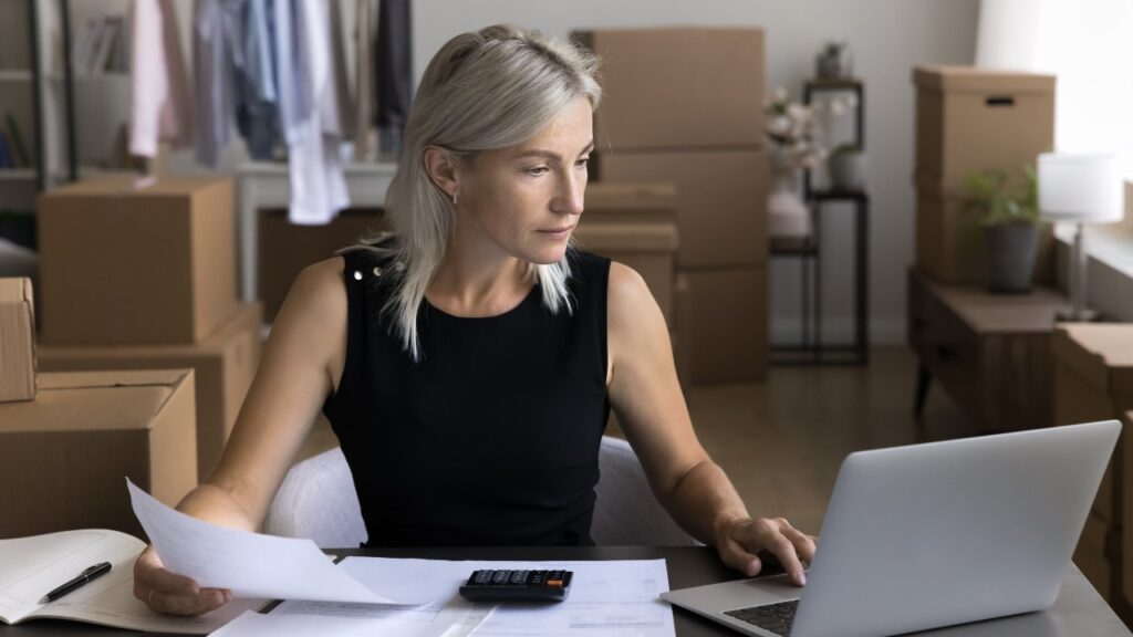 woman web shop owner use pc calculator in accounting work pay bills online