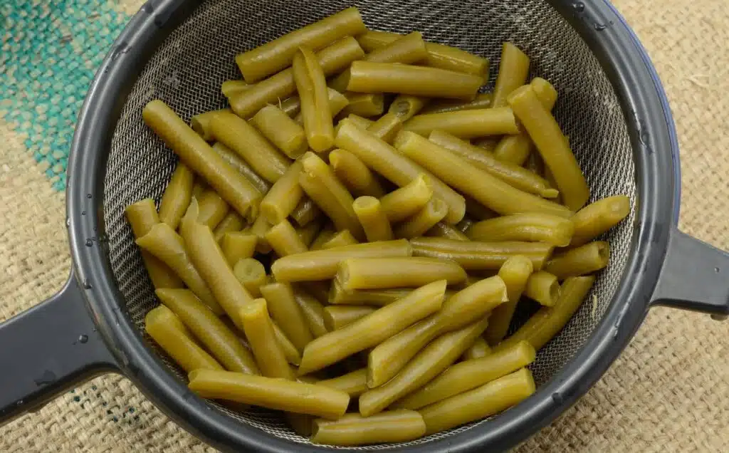 Close up of rinsed canned green beans in strainer
