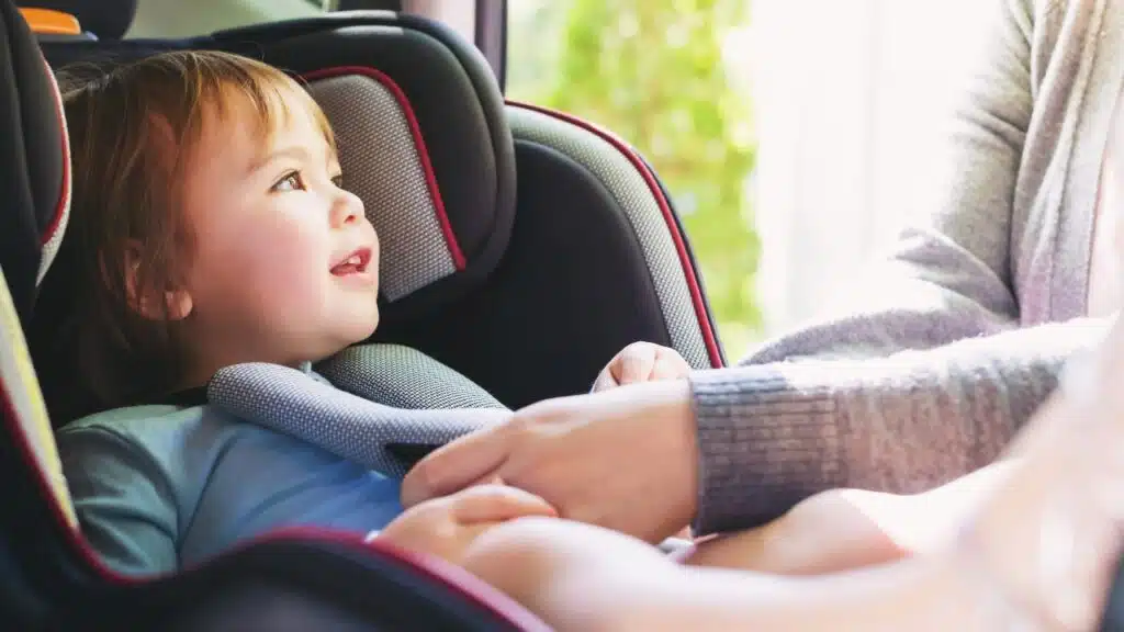Toddler girl buckled into her car seat.