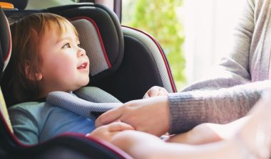 Toddler girl buckled into her car seat.