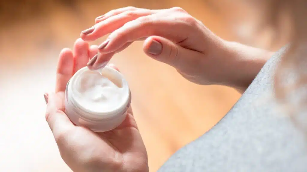 young woman uses body care cream, representing Genius Collagen Cosmetics class action lawsuit