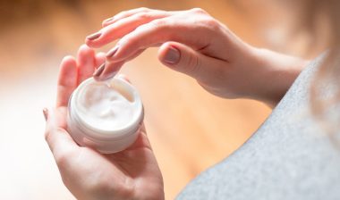 young woman uses body care cream, representing Genius Collagen Cosmetics class action lawsuit