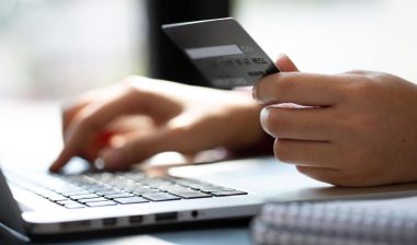 Close up woman hand using credit card and smartphone laptop for buying online shopping