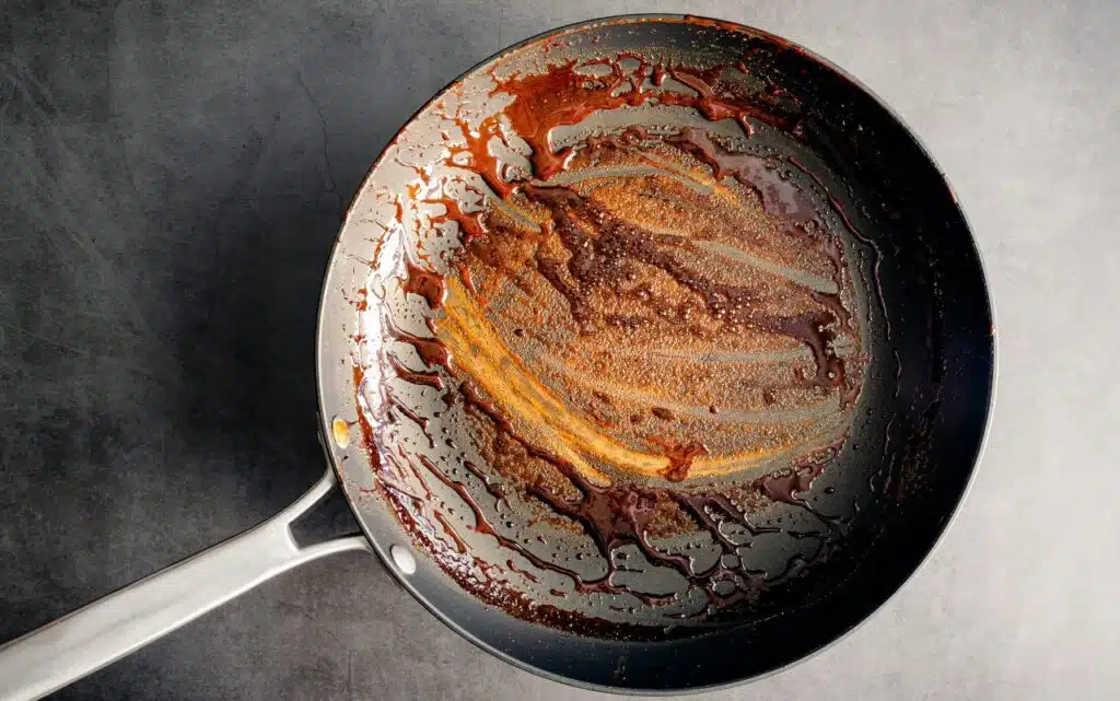 Dirty Nonstick Skillet Used to Make a Balsamic Reduction: An unwashed frying pan covered in a sticky glaze