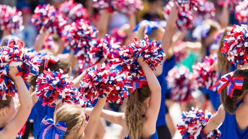 Cheerleaders Waving Red, White, and Blue Pom Poms, representing the Varsity Brands class action settlement