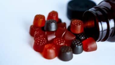 Vitamin gummies with a bottle on a white background.