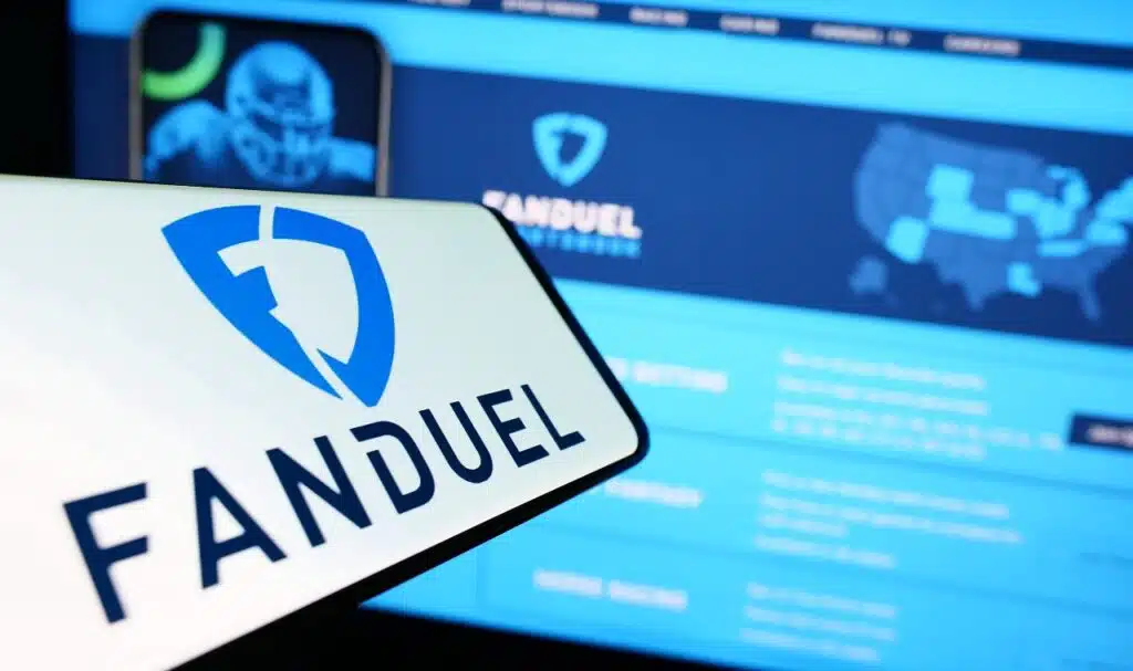 Smartphone with logo of American gambling company FanDuel Inc. on screen in front of business website.