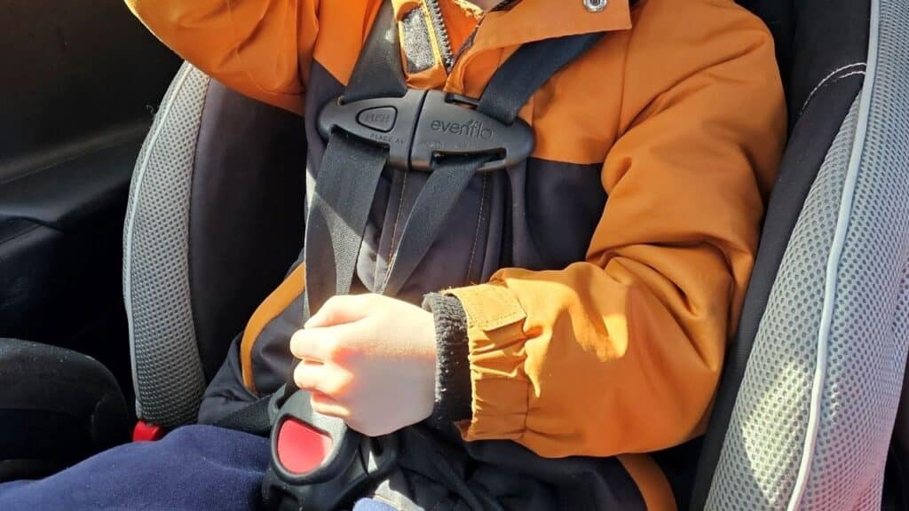 A child looking at their new toy as they sit in a car seat.
See less