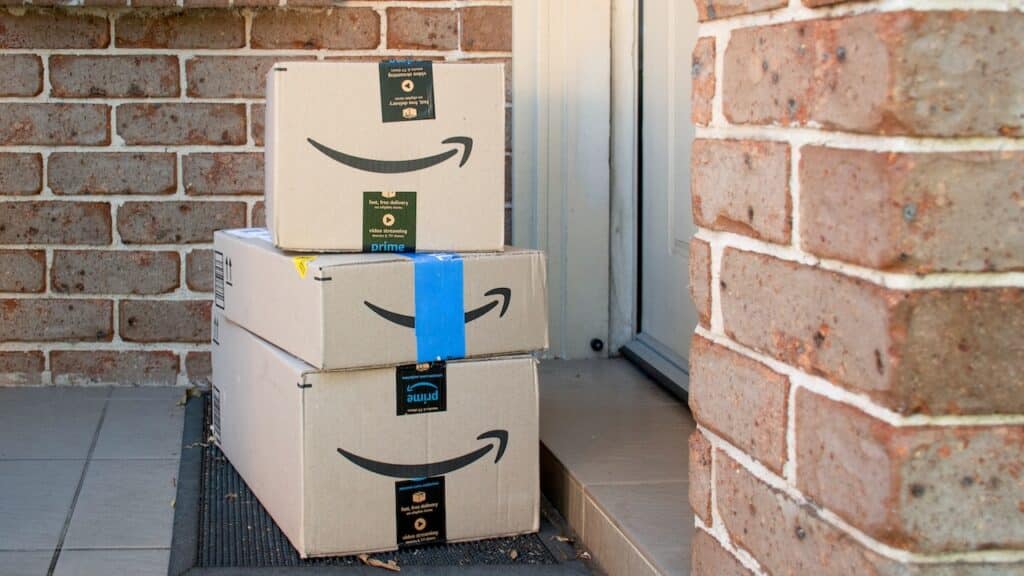Amazon prime boxes and envelopes delivered to a front door of residential building.