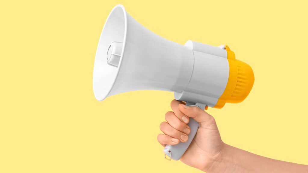 Female hand with megaphone on yellow background, representing the latest recalls in March 2025.