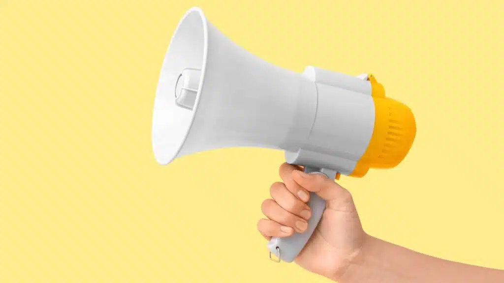 Female hand with megaphone on yellow background, representing the latest recalls in March 2025.