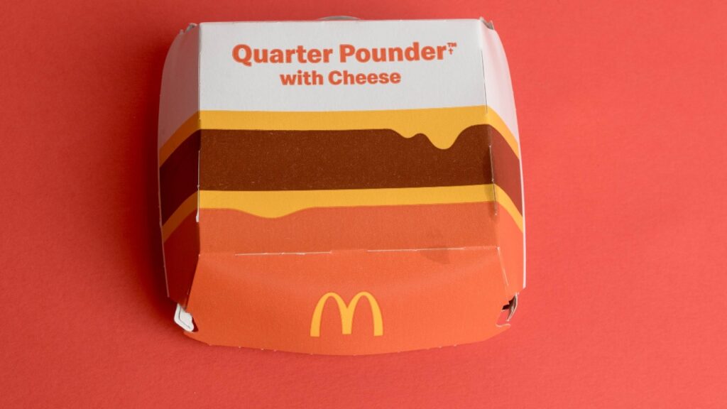 A view of a McDonalds Quarter Pounder With Cheese box, against a red background.
