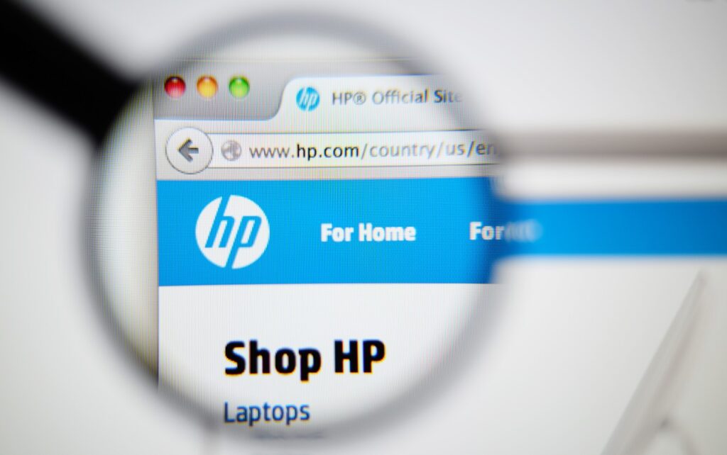 Photo of HP homepage on a monitor screen through a magnifying glass.