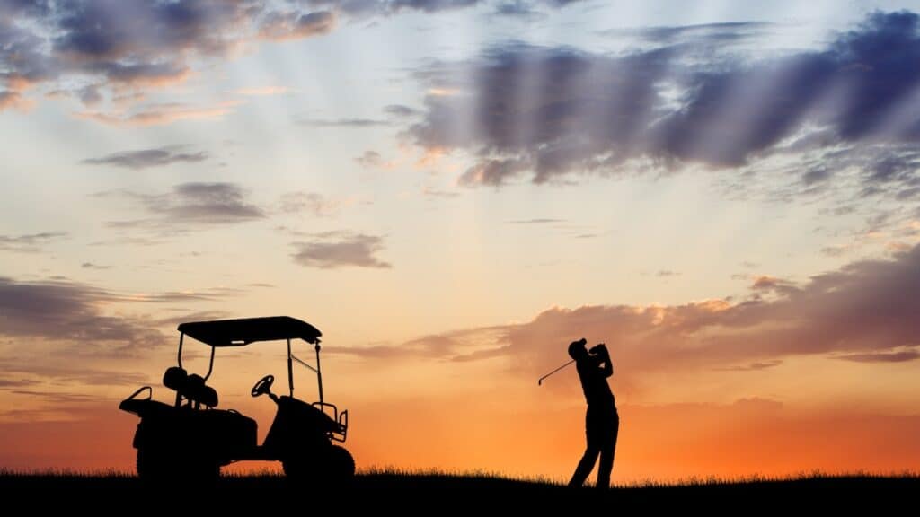 Silhouette of golfer and golf cart