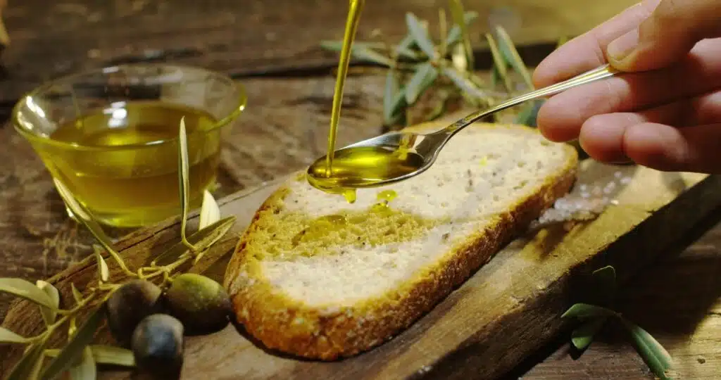 organic oil cold pressed in slow motion falls on organic bread, representing Madhava oils class action lawsuit
