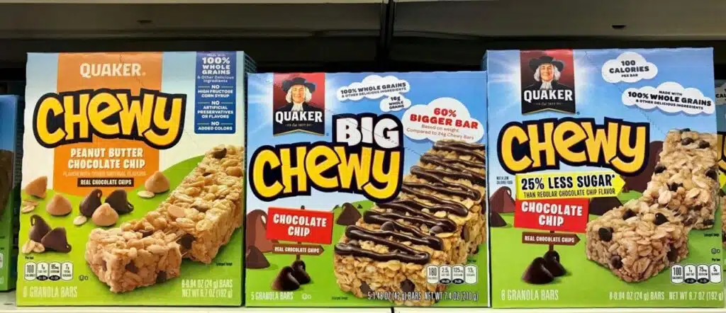 Grocery store shelf with boxes of Quaker Oats Chewy Granola bars in various flavors, Quaker Oats is an American food company founded in 1901.