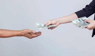 Woman's hand hold and send US dollar to another hand isolated on white background