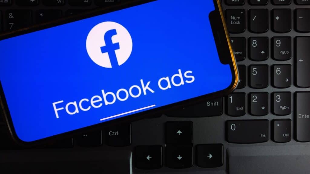 Facebook Ads logo displayed on smartphone screen in the office.