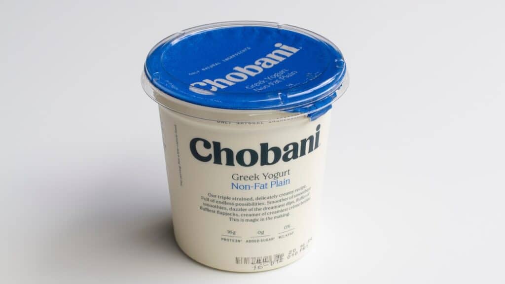 A tub of Chobani brand non-fat plain Greek Yogurt (32oz) isolated on a white background.