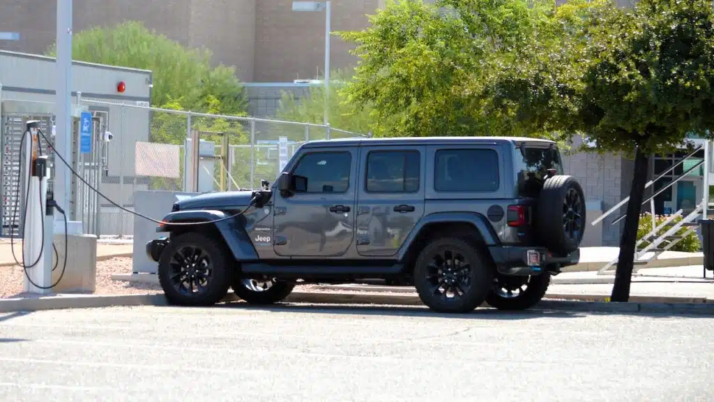 A Jeep Wrangler 4xe Sahara gas electric plug-in hybrid model charging at a ChargePoint EV station at an employee workplace.