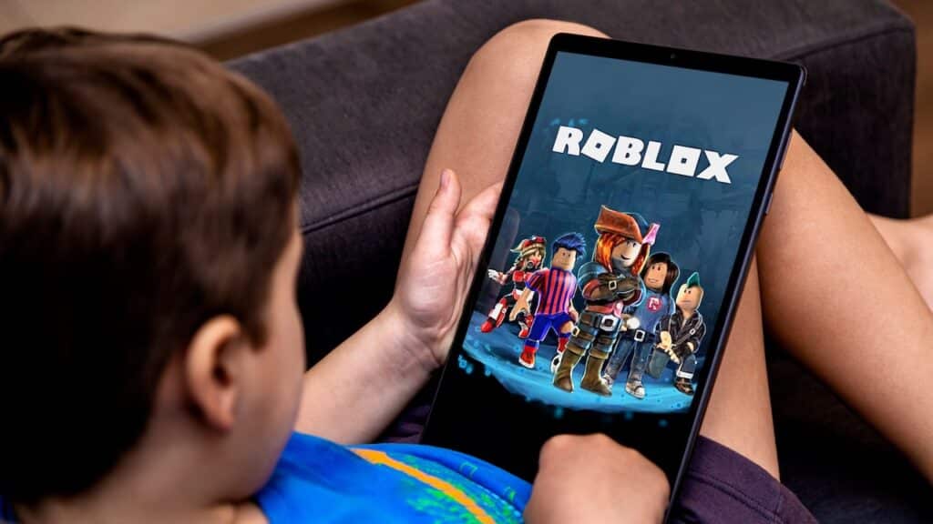 Little boy playing Roblox game on a tablet.