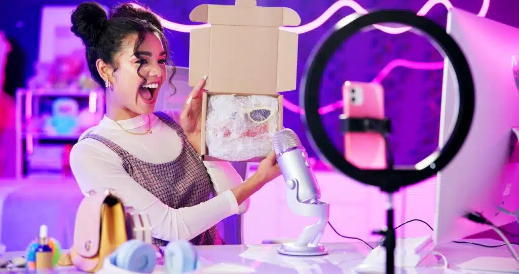 Unboxing, influencer and girl live streaming by phone and ring light for product review, sponsorship or designer brand.
