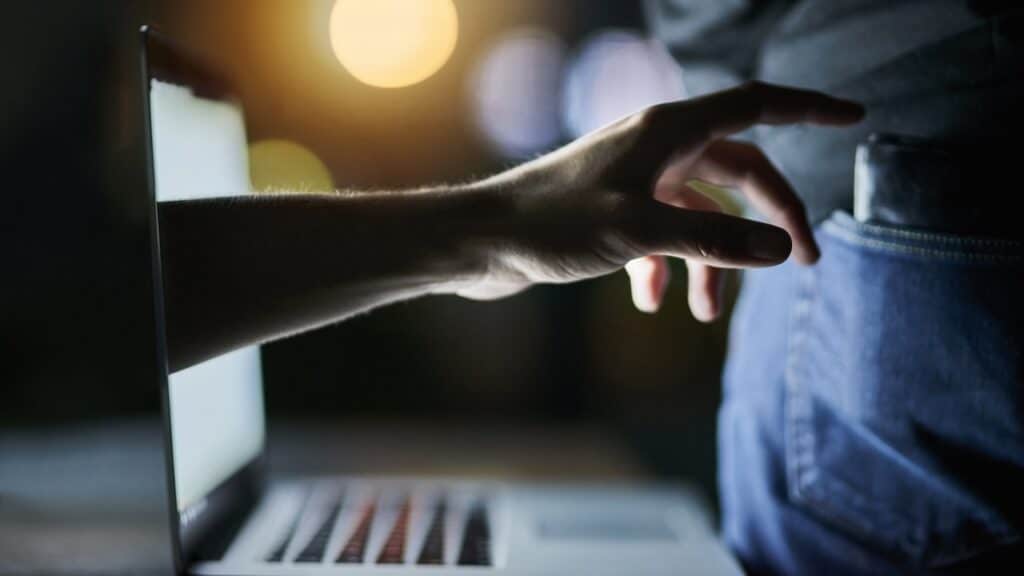 Laptop, hand and wallet for cyber or crime with digital pickpocketing, online scam and cybersecurity breach.