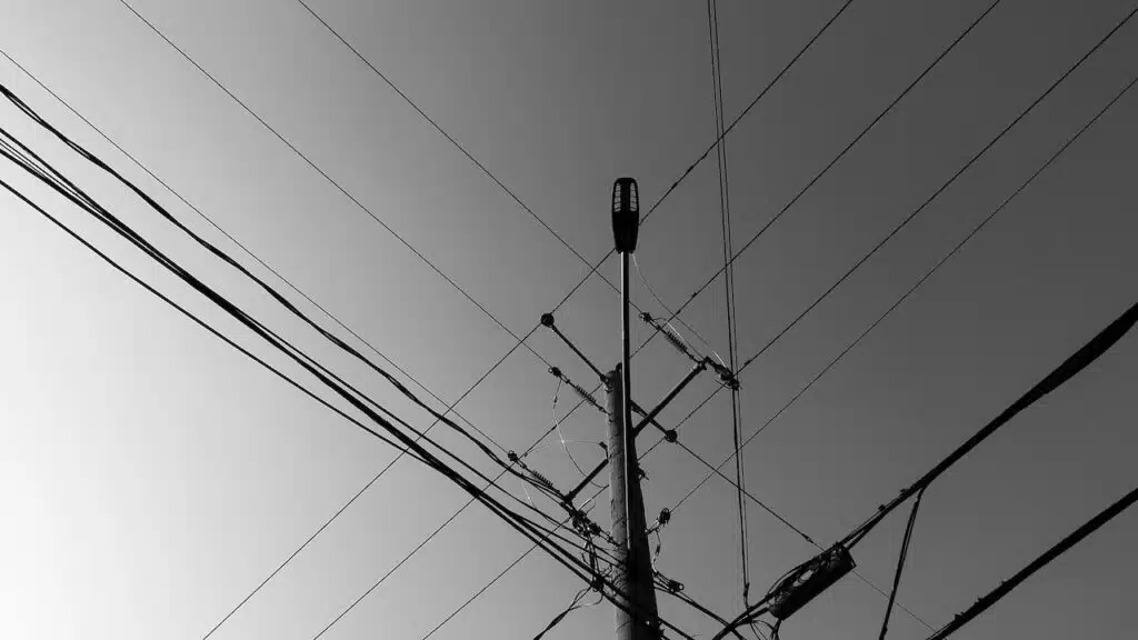 post in black and white, telephone and power lines in the city