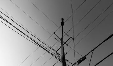 post in black and white, telephone and power lines in the city