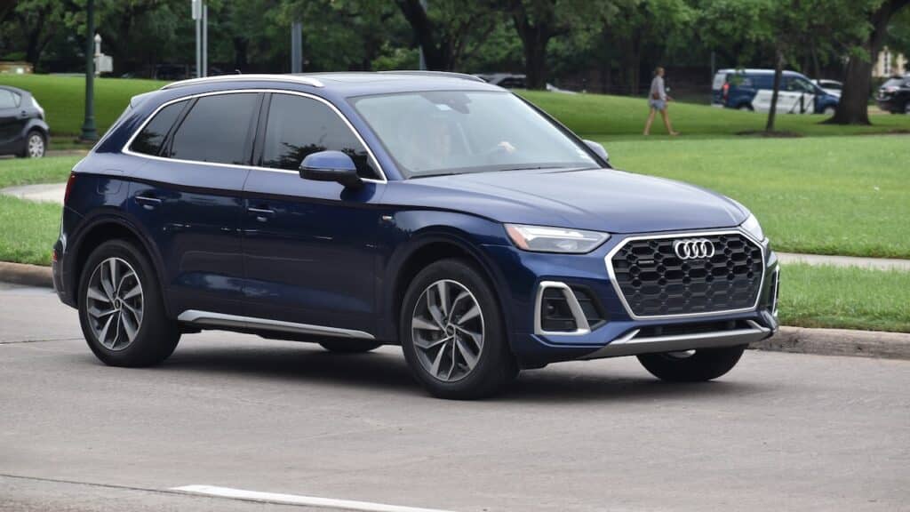 A blue Audi Q5 luxury SUV cruising at a nature reserve.