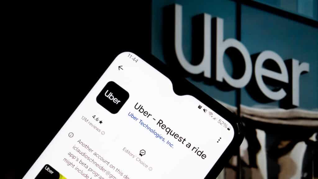 Man holds smart phone with Uber application on the screen. Uber is an American multinational transportation company that provides ride-hailing services.