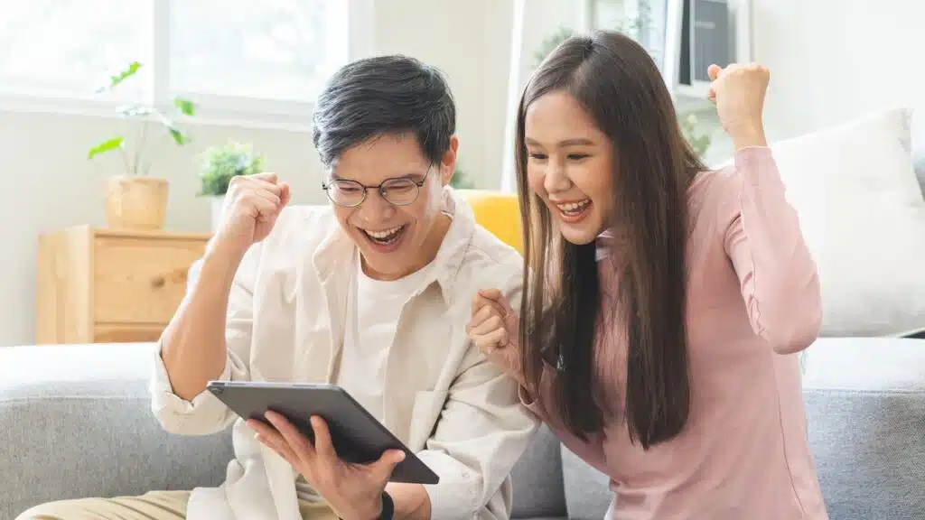 Happy excited, smiling couple received or getting cash back
