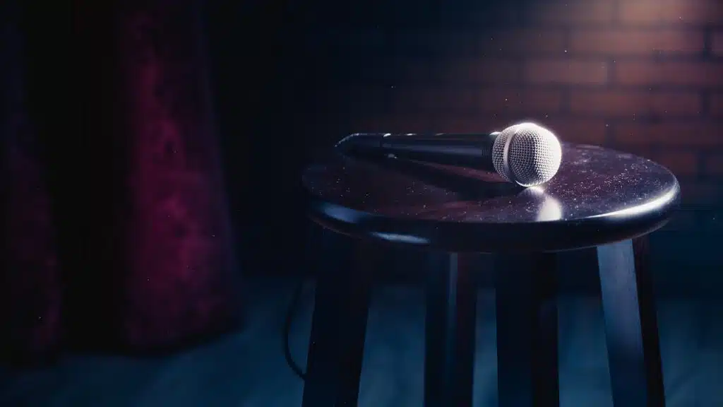 microphone on a wooden stool on a stand up comedy stage with reflectors ray.