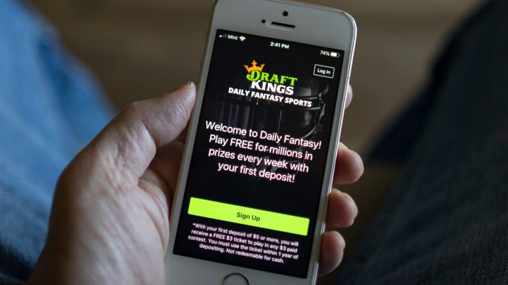 A man opens the DraftKings app from his iPhone. DraftKings is an American daily fantasy sports contest and sports betting operator.