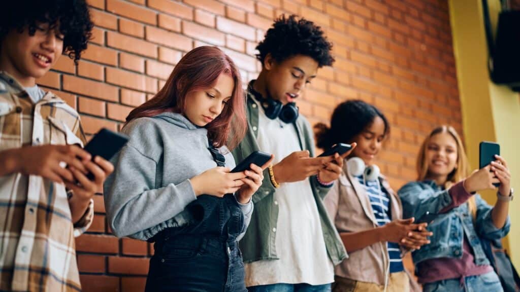 High school students using smart phones on a break at school.
