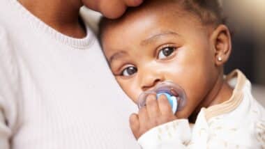 Mom, care and baby portrait with pacifier