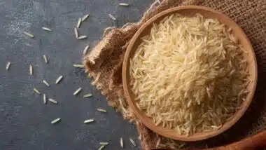 close-up of raw basmati rice grains on black textured table top surface