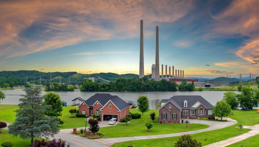 Toxic emissions from thermal power plant polluting air in city suburbs. Electricity production by burning coal fossil fuel.