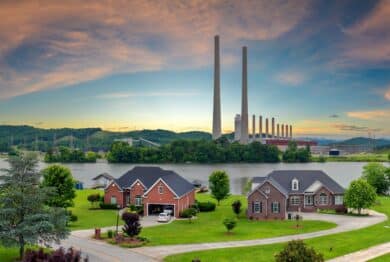 Toxic emissions from thermal power plant polluting air in city suburbs. Electricity production by burning coal fossil fuel.