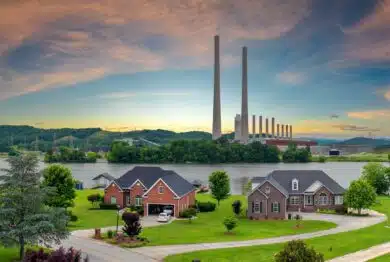 Toxic emissions from thermal power plant polluting air in city suburbs. Electricity production by burning coal fossil fuel.
